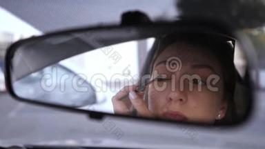 一个漂<strong>亮</strong>的<strong>白</strong>人女孩看着汽车的后视镜，把阴影放在她的眼睛上。 违反法律